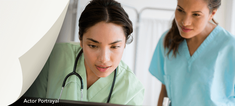 Two healthcare professionals reviewing cardiac ultrasound data on a computer in a hospital setting